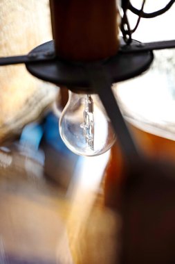 Abajur gölgesinde parlak bir ampul. Üst manzara, yakın çekim, sığ alan derinliği, insan yok.