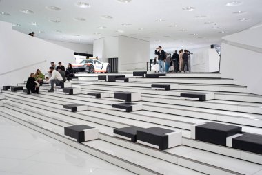 14-09-2024, Stuttgart, Germany. Porsche museum exhibition hall. Visitors walking around the exhibition halls looking at the cars. clipart