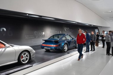 14-09-2024, Stuttgart, Almanya. Porsche Müze Sergi Salonu. 911 turbo jenerasyon, tip 993 arka görüş. İnsanlar sergilere bakıyor.
