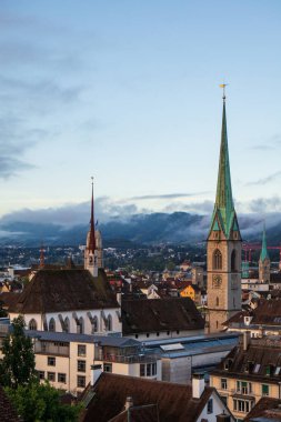 Bir Avrupa şehrinde Katolik Kilisesi saat kulesi. Huysuz ışık, yaz sabahı, yüksek görüş açısı, insan yok..