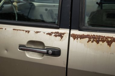 Eski, paslı araba gövde panelleri. Eski bir arabanın pas bantlarını yakın çekim, insan yok..