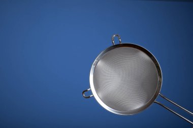 Paslanmaz çelik elek. Stüdyoyu kapat, mavi üzerine izole edilmiş..