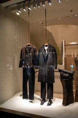 Erkek manken vitrin vitrininde gündelik sonbahar kıyafetleri giyer. Kış şık giysileri, gece manzarası..