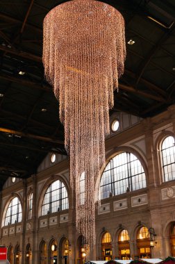 17-12-2024 Zürih, İsviçre. Zürih ana istasyonunda kırmızı Lindt çikolata toplarıyla süslenmiş büyük bir Noel ağacı. Geniş açılı görüş, insan yok, yukarı bakıyor..