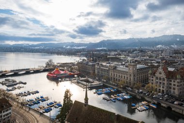 24-12-2024 Zürih, İsviçre. Limmat nehrinin hava manzarası Zürih Gölü 'ne doğru yükseliyor. Kış günü, Burkiplatz 'ın geniş açılı manzarası, Quai köprüsü ve nehirdeki rıhtımlı tekneler..