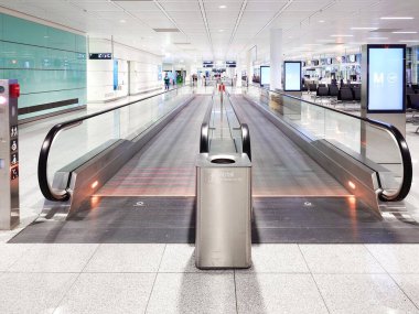 27-12-2024 Munich International Airport, Germany. Long rolling walkways inside departure terminal clipart