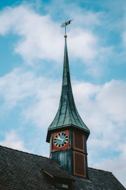 Avrupa 'da küçük bir kilise saati ve çan kulesi. Düşük açı, kısmen bulutlu gökyüzü, insan yok.