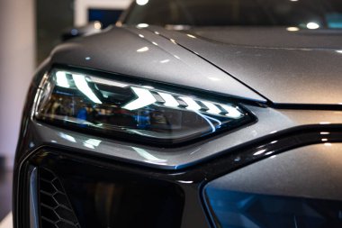 07.03.2025, Münih Uluslararası Havaalanı, Almanya. Audi e-tron GT elektrikli sedan far detayı havaalanı terminalinde çekildi. Ön manzara, sığ alan derinliği, insan yok.