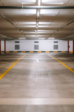 Boş, aydınlık yeraltı otoparkı. Geniş açı, insan yok, araba yok..