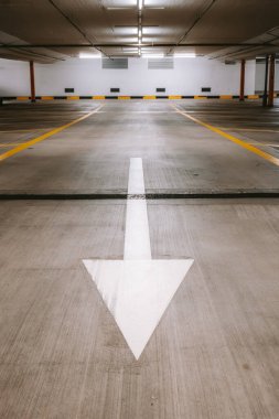 Boş, aydınlık yeraltı otoparkı. Geniş açı, insan yok, araba yok..