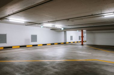 Boş, aydınlık yeraltı otoparkı. Geniş açı, insan yok, araba yok..