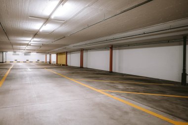 Boş, aydınlık yeraltı otoparkı. Geniş açı, insan yok, araba yok..