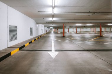 Boş, aydınlık yeraltı otoparkı. Geniş açı, insan yok, araba yok..