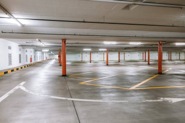 Boş, aydınlık yeraltı otoparkı. Geniş açı, insan yok, araba yok..