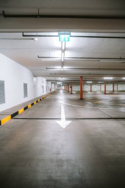 Boş, aydınlık yeraltı otoparkı. Geniş açı, insan yok, araba yok..