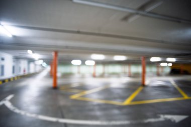 Bulanık, boş, aydınlık yeraltı otoparkı. Geniş açı, insan yok, araba yok..