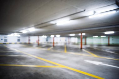 Bulanık, boş, aydınlık yeraltı otoparkı. Geniş açı, insan yok, araba yok.