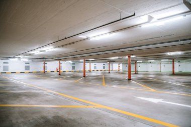 Boş, aydınlık yeraltı otoparkı. Geniş açı, insan yok, araba yok..