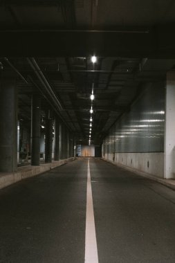Karanlık, boş, loş bir yeraltı tüneli. Perspektif azalıyor, insan yok..