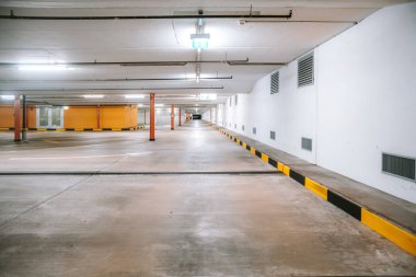 Boş, aydınlık yeraltı otoparkı. Geniş açı, insan yok, araba yok..