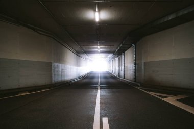 Karanlık, boş, yeraltı tünelinin sonundaki parlak ışık. Geniş açı görünümü, insan yok..