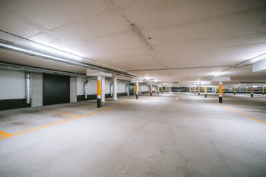 Boş, aydınlık yeraltı otoparkı. Geniş açı, insan yok, araba yok..