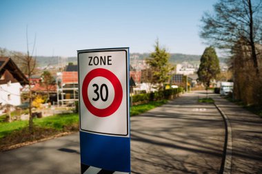 Şehir tabelaları maksimum sürat sınırını 30 olarak belirliyor. Yakın çekim, sığ alan derinliği, şehir geçmişi, araba yok, insan yok..