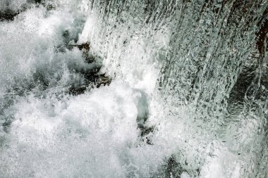 Şelale sıçrama dokusu ya da arka plan. Hızlı deklanşör hızı, donmuş hareket, yakın çekim, insan yok..