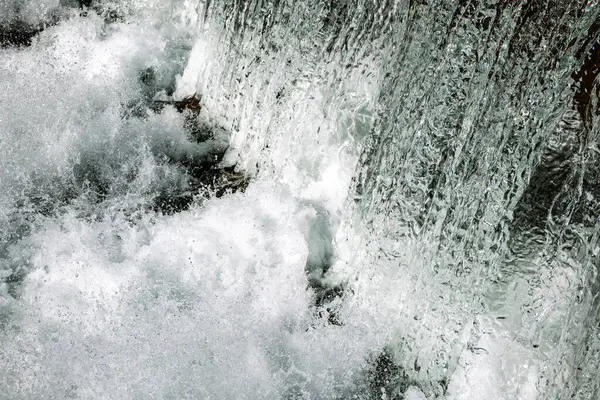 Şelale sıçrama dokusu ya da arka plan. Hızlı deklanşör hızı, donmuş hareket, yakın çekim, insan yok..