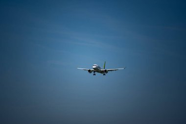 Mavi gökyüzü arka planına kurulmuş ticari bir uçak. Yukarı bakıyor, telefoto çekimlerini kapatıyor..