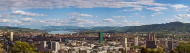 16-05-2025 Zürih, İsviçre. Yukarıdan tepeden bakıldığında panoramik bir manzara. Bulutlu gökyüzü, karlı Alpler ve arka planda Zürih Gölü.