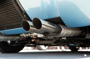 İkiz uçlu araba egzoz borusu ya da egzoz borusu. Düşük açı, krom metal, insan yok..