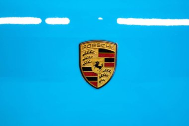 Porsche kaput ya da kaput amblemi ya da rozet. Üstten aşağı, yakın görüş, açık mavi araba, insan yok.