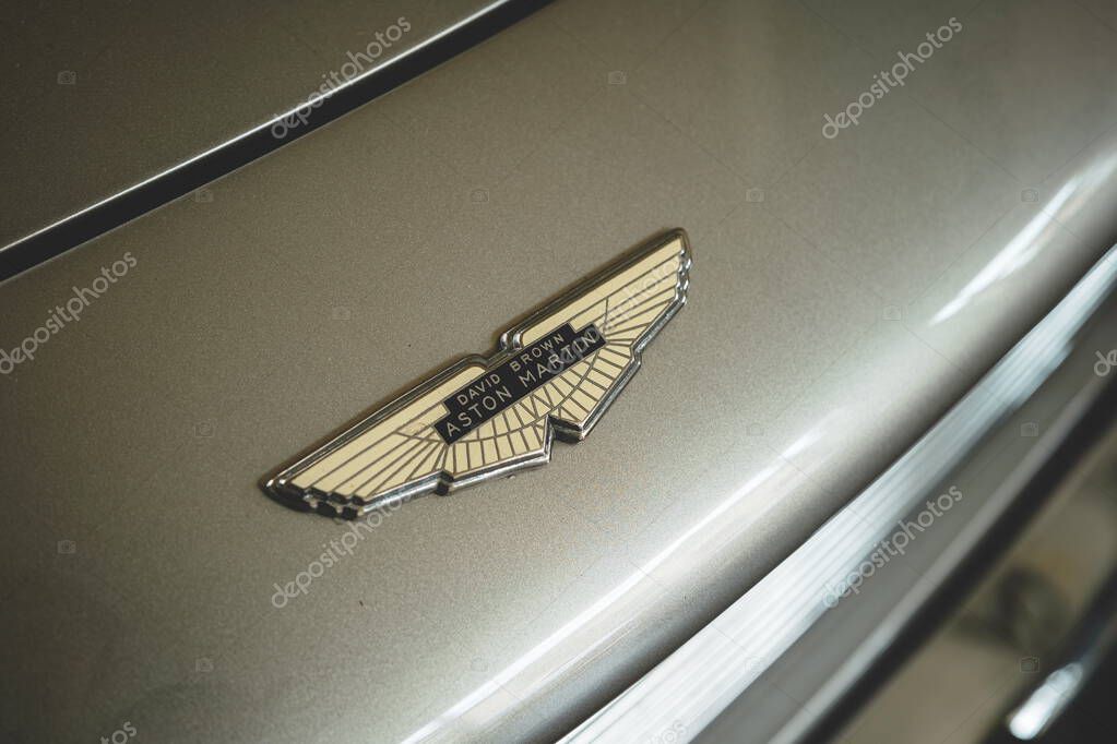 08-06-2025, Kempttal, Switzerland.Aston Martin hood or bonnet ornament emblem or badge on a youngtimer car. Top down, close up detail shot, no people
