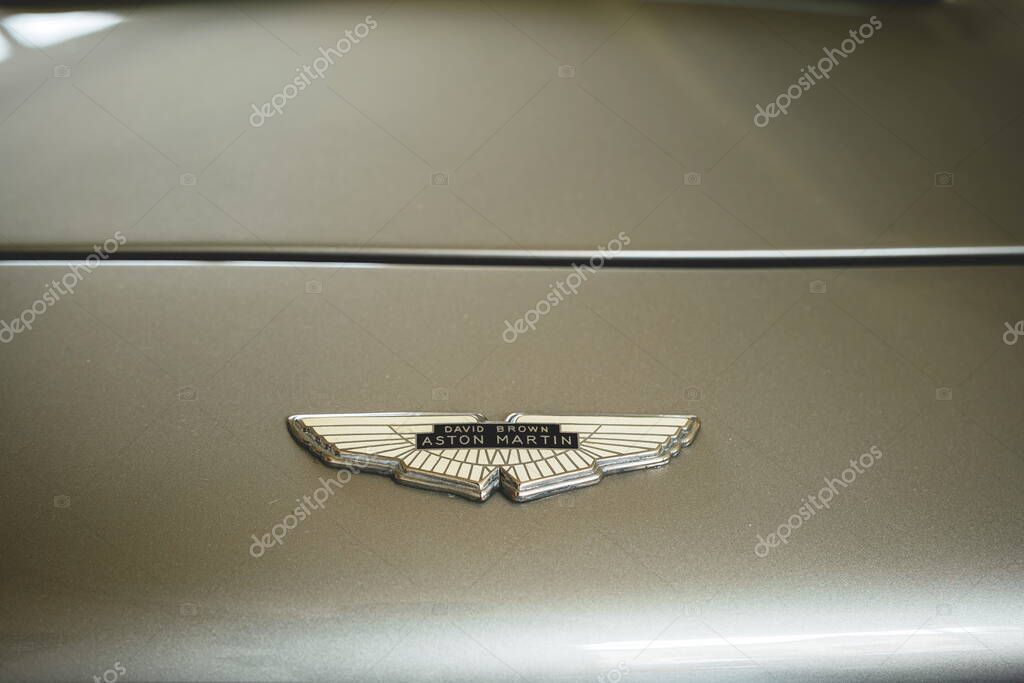 08-06-2025, Kempttal, Switzerland.Aston Martin hood or bonnet ornament emblem or badge on a youngtimer car. Top down, close up detail shot, no people
