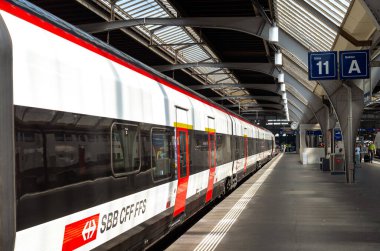 16-06-2025 Zürih, İsviçre. SBB treni Zürih ana tren peronunda, geniş açı manzaralı, doğal ışık, cam çatı tavanı