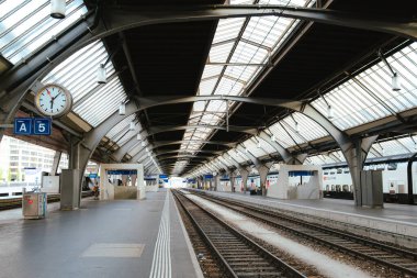 30-06-2025 Zürih, İsviçre. Ana istasyonun içinde boş tren rayları ve platform var. Geniş açı, doğal gün ışığı.