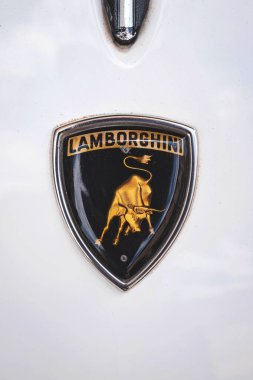 05-07-2025 Kemptthal, İsviçre. Klasik Lamborghini başlık rozeti ya da ünlü boğa dövüşçüsünü gösteren kalkan. Yakın çekim, beyaz klasik Espada, insan yok.