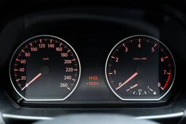 Aydınlatılmış analog BMW enstrüman kümesi veya çevirme göstergeleri. Yakın çekim, insan yok.