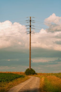 Avrupa 'da bir alanda elektrik hattı direği. Kısmen bulutlu bir yaz günü, insan yok.