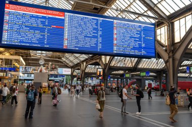 17-07-2025 Zürih, İsviçre. Hauptbahnhof ya da ana istasyon ana avlu salonu. İnsanlar büyük dijital zaman tablosunu kontrol ediyor.
