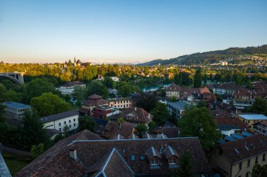 07-08-2025 Bern, İsviçre. Gün batımında ünlü Bundesterrasse gözlem güvertesinden görüntü. Güneşli yaz akşamı ışığı, eski şehrin geniş açılı manzarası ve arka planda Alpler, kimse yok.