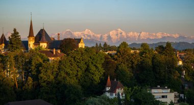 07-08-2025 Bern, İsviçre. Gün batımında ünlü Bundesterrasse gözlem güvertesinden görüntü. Güneşli yaz akşamı ışığı, eski kasabanın telefon görüntüsü ve arka planda Alpler, kimse yok.