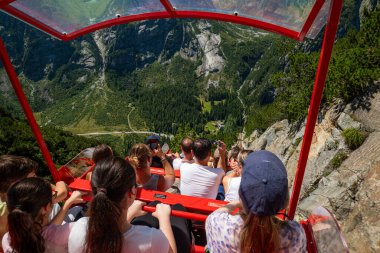 07-08-2025 Handegg, İsviçre. İnsanlar ünlü Gelmerbahn teleferiğine biniyor. Güneşli bir yaz öğleden sonrası, geniş açı, dik tırmanış açısı, vadideki Alpler 'in muhteşem manzarası.