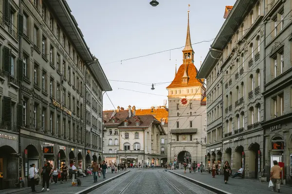 07-08-2025 Bern, İsviçre. Spitalgasse 'deki ünlü Kafigturm saat kulesi. Yaz sonu akşam ışığı, geniş açı manzarası.
