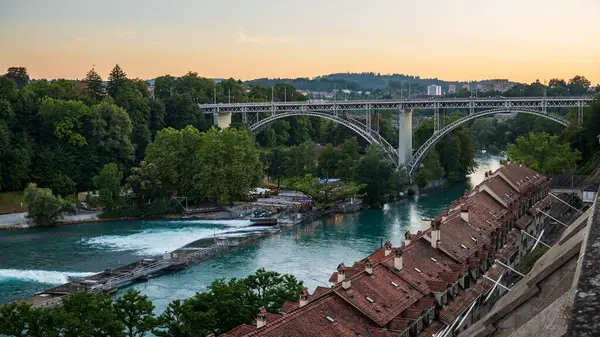 07-08-2025 Bern, İsviçre. Gün batımında ünlü Kirchenfeld Köprüsü ve Aare Nehri manzarası. Güneşli yaz akşamı ışığı, geniş açı manzarası