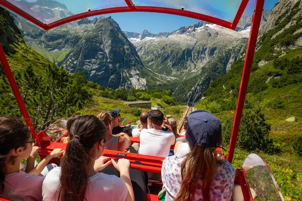 07-08-2025 Handegg, İsviçre. İnsanlar ünlü Gelmerbahn teleferiğine biniyor. Güneşli bir yaz öğleden sonrası, geniş açı, dik tırmanış açısı, vadideki Alpler 'in muhteşem manzarası.