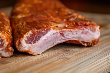 Çiğ, baharatlı ve terbiye edilmiş domuz pirzolası ya da ahşap bir mutfak tahtasında pirzola. Yakın çekim, insan yok.