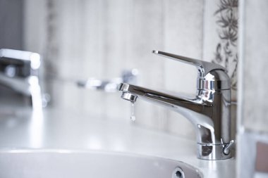 Daire banyosunun içine su damlacıkları damlatıyor. Macro, yakın çekim, alan derinliği, insan yok.