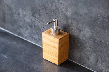 Kare şeklinde, sahte ahşap kaplama sabun makinesi. Yakın çekim, granit tezgah arka plan, insan yok.